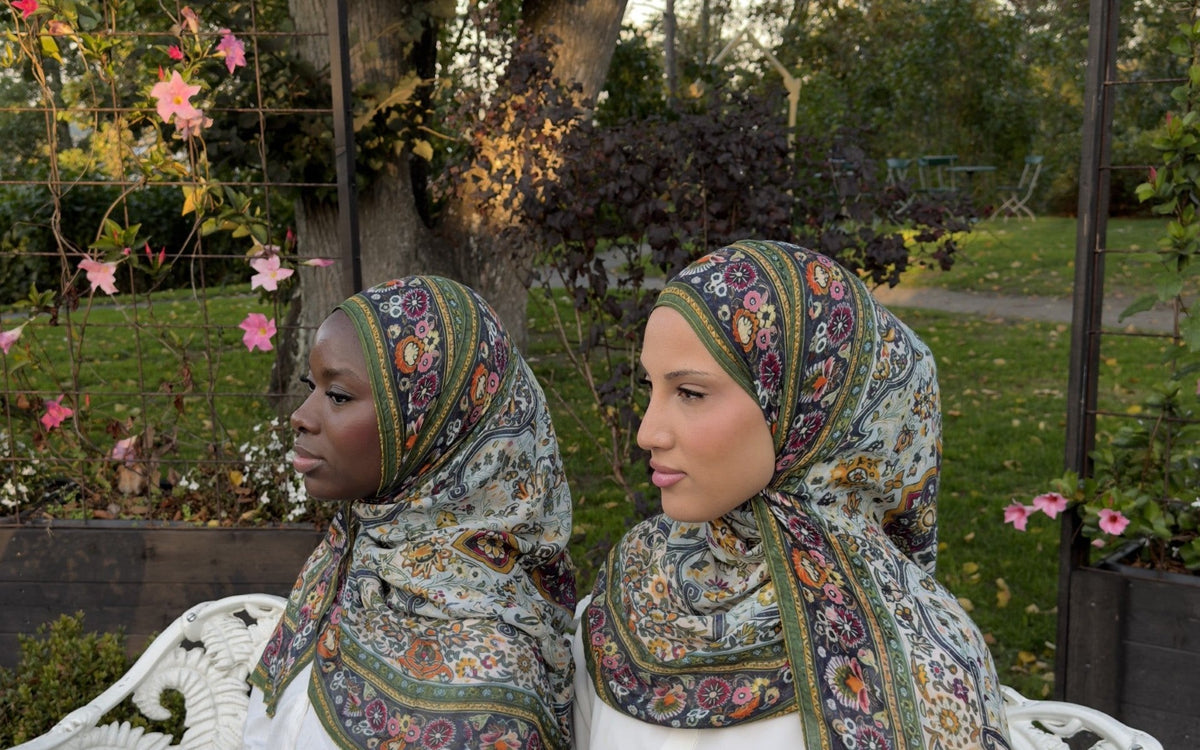 Two women in printed modal hijabs sitting on a white garden bench